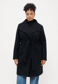 Zwart jasje met brede revers, een ceintuur op de taille en lange mouwen, gemaakt van een zachte, textuurstof. Geen zichtbare patronen.
