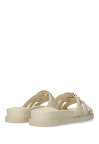 Sandali beige con cinturini larghi, suola piatta e sottili dettagli dorati. Realizzati in materiale liscio con un design aperto sul retro.