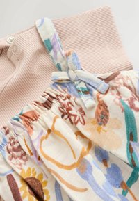 Obleka s cvetličnim vzorcem in bež bodijem z rebrasto tkanino, ki ima nastavljive naramnice in nabran material v pastelnih barvah.