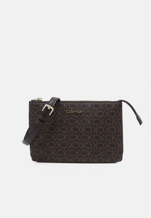 Rechthoekige Calvin Klein schoudertas met donkerbruin monogrampatroon, gouden logo, zwarte verstelbare band en bovenste ritssluiting.