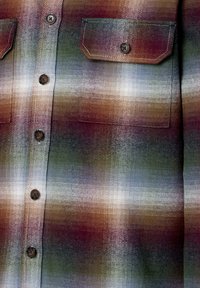 Kariertes Hemd aus einer Mischung erdiger Töne wie Braun, Grün und Blau. Hergestellt aus einem Stoff mit strukturiertem Finish und zwei Brusttaschen.