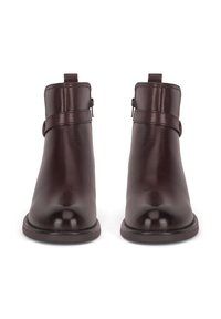 Brązowe skórzane botki za kostkę o gładkiej fakturze, zaokrąglonym czubku i detalach z boku w postaci klamer. Posiadają uchwyt do łatwego zakładania.