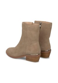 Bottines en suède taupe avec un bout arrondi, un petit talon et une fermeture éclair à l'arrière. Accent en argent à la base du talon. Texture lisse et lignes épurées.