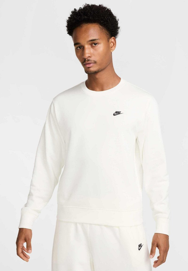 Felpa bianca a girocollo realizzata in tessuto morbido, con un piccolo logo Nike nero sul petto e polsini e orlo a costine.