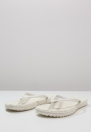 White flip-flops with woven straw soles, flat rubber straps, and textured footbed. Simple design with a neutral color palette.