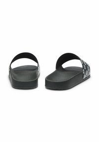 Czarne klapki na płaskiej podeszwie z fakturowaną zewnętrzną podeszwą i gładkim wewnętrznym podbiciem. Posiadają szerokie paski z powtarzającym się wzorem logo.