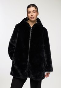 Czarny płaszcz z sztucznego futra z kapturem, z suwakowym zapięciem z przodu, długimi rękawami i luźnym krojem. Miękka faktura bez widocznych wzorów lub detali metalowych.
