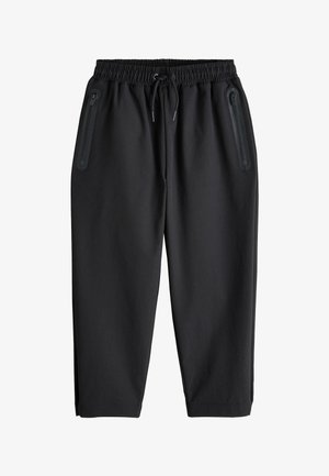 Sorte afslappede bukser med elastisk talje og snøre samt to lodrette lynlåslommer foran, vist på hvid baggrund.