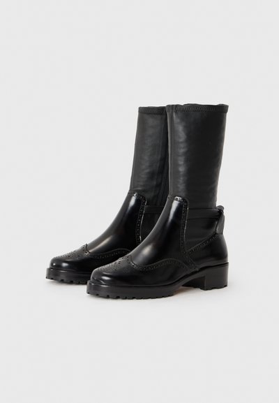 Czarne skórzane botki z gładką powierzchnią, okrągłym noskiem, ozdobnymi perforacjami i niskim, szerokim obcasem, wyposażone w elastyczny panel boczny.