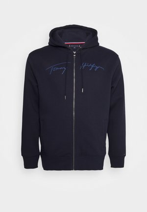 Felpa con cappuccio blu navy con zip integrale, cappuccio con coulisse, tasche frontali e logo in corsivo stampato sul petto.