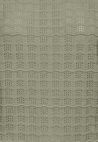 Țesătură tricotată gri deschis cu un model repetitiv de găuri verticale în formă de evantai și creste orizontale ridicate.