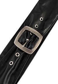 Ceinture en cuir noir avec une finition texturée, dotée d'une boucle carrée métallique argentée et d'œillets pour un ajustement de la taille.