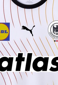 Witte sporttrui met zwarte ronde kraag, voorzien van rode en oranje diagonale strepen, Puma-logo, een Lidl-badge en "atlas" in vetgedrukte zwarte tekst.