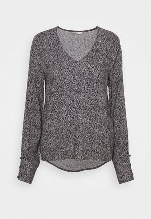 Blouse à manches longues noire avec un motif abstrait blanc, col en V et ourlet arrondi. Dotée de boutons aux poignets. Tissu lisse.