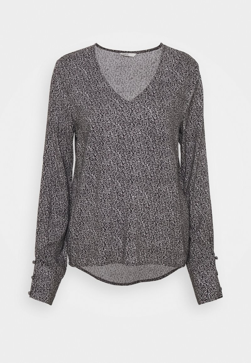 Blusa de manga larga en negro con un patrón abstracto blanco, escote en V y dobladillo redondeado. Presenta botones en los puños de las mangas. Tejido liso.