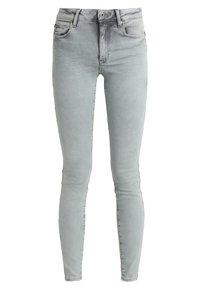 Jeans ajustados en denim gris claro, con un clásico diseño de cinco bolsillos, un sutil desgaste y un cierre frontal de botón con cremallera.