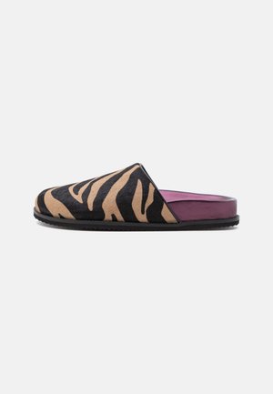 Mule slip-on avec des rayures tigre marron et noires sur la tige et une semelle intérieure violette coussinée, vue de profil sur fond blanc.