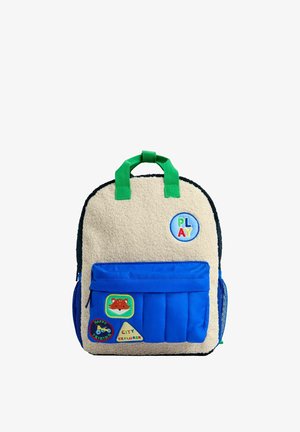 Small children's backpack with beige fleece front, blue front pocket, green handles, and colorful patches including "PLAY," a fox, and "City Explorer."
