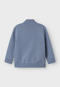 Blå sweatshirt med hög krage, ribbade mudd och nederkant. Tillverkad av mjukt material, har en enkel, ren design utan mönster.