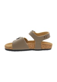 Sandale beige à bout ouvert avec brides ajustables, semelle en liège, semelle intérieure matelassée et semelle extérieure en caoutchouc noir texturé.