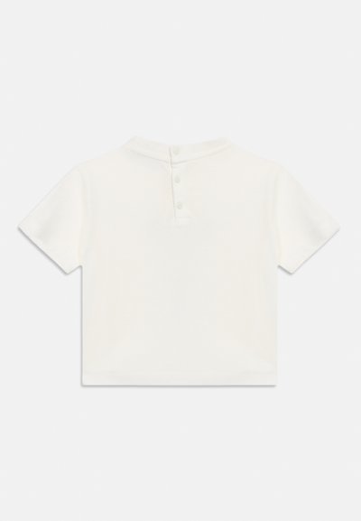 Απλό λευκό κοντομάνικο μπλουζάκι με στρογγυλή λαιμόκοψη και τρία κουμπιά στο πίσω μέρος του λαιμού, εμφανιζόμενο επίπεδα σε λευκό φόντο.