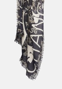 Ciemny szalik z tkaniny z dużymi białymi abstrakcyjnymi wzorami i frędzlami wiszący na jednolitym białym tle.