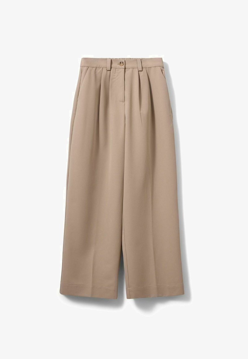 Pantalon beige à jambes larges avec plis, passants pour ceinture, poches latérales et fermeture à bouton à la taille.