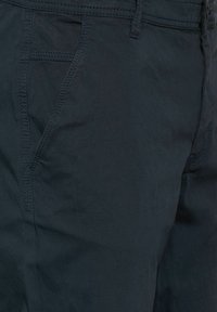 Pantalones cortos de un oscuro color azul marino, confeccionados con una tela ligera, que presentan una textura suave, bolsillos laterales y detalles de costura visibles.