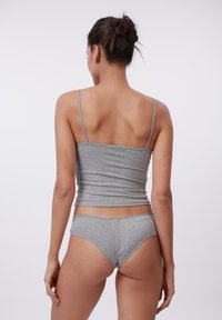 Tricou fără mâneci de culoare gri, cu benzi subțiri și lenjerie asortată. Materialul pare moale, cu o textură netedă și un design ajustat.