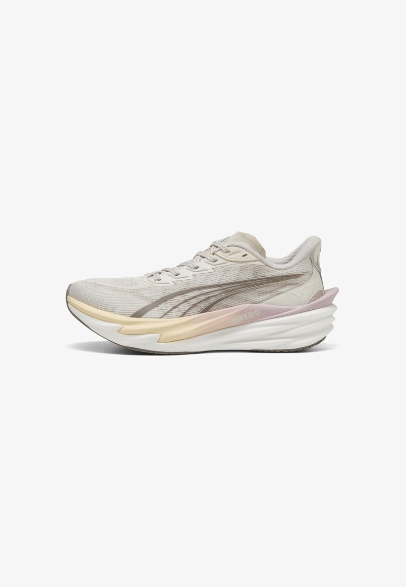 Chaussure de course beige clair et rose, rembourrée, avec tige en mesh, lacets et semelle épaisse sculptée, conçue pour la performance athlétique.