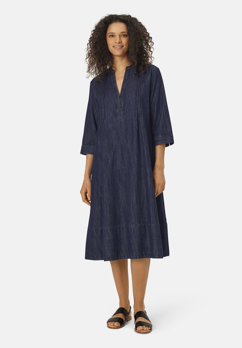 Denim-mekko, syvän sininen väri, polvipituinen, löysä malli, nappilista, kolme neljännestunnin hihaa ja sivusaumapocketit.