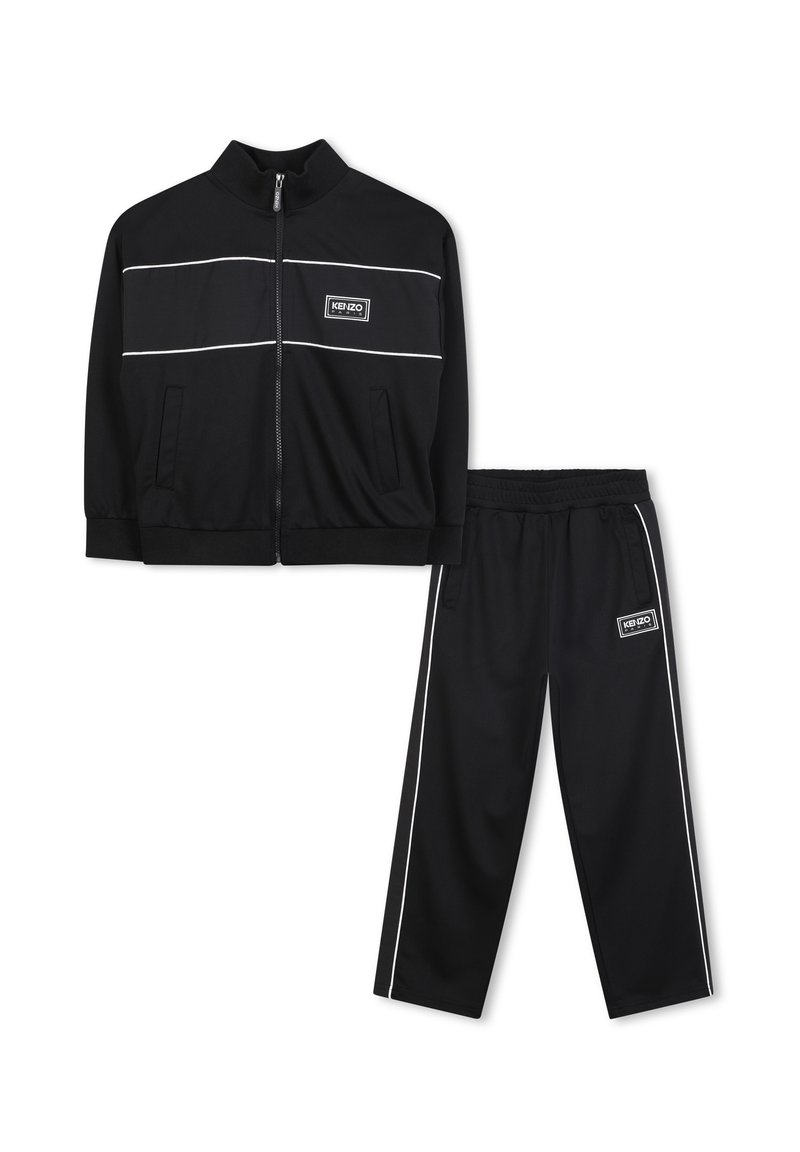 Tuta nera composta da una giacca con zip con strisce bianche e logo, abbinata a pantaloni coordinati con vita elastica e strisce laterali.