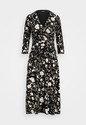 Vestido negro de manga larga con patrón floral blanco, escote en V y cinturilla con lazo. Hecho de una tela suave, con una falda fluida.