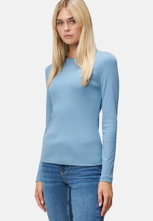 Blauw langgliedig shirt gemaakt van zachte stof, met een ronde hals en een getailleerde silhouet, gecombineerd met blauwe jeans. Eenvoudig en naadloos ontwerp.