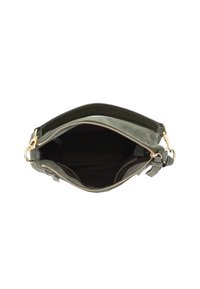 Grüne Wildledertasche und schwarze Lederhandtasche mit goldfarbigem Reißverschluss, geöffnet, um das leere Innenfutter aus dunklem Stoff zu zeigen und abnehmbare Riemen, die an den Seiten eingeklipst sind.