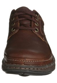 Bruine lederen schoen met ronde neus, bijpassende veters en metalen oogjes. Heeft decoratieve stiksels en een gestructureerde rubberen zool.