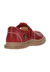 Red leather shoe with a Velcro strap, contrasting white stitching, rounded toe, cushioned insole, and a flexible, translucent sole.