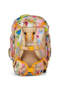 Zaino colorato per bambini con una base pastello, motivo a pois in rosa, arancione, verde e blu, dotato di spallacci arancioni e fodera in rete.