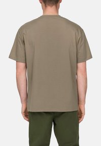 Kurzärmeliges T-Shirt mit Rundhalsausschnitt aus olivgrünem Baumwollstoff. Bietet eine lockere Passform, eine glatte Textur und eine minimale Markenkennzeichnung am Saum.