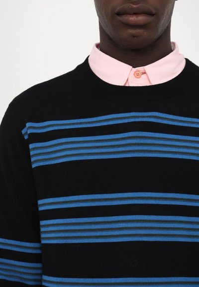 Un pull noir avec des rayures horizontales bleues, porté par-dessus une chemise à col rose. Il présente un col côtelé et un motif de tricot texturé.