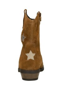 Brown suede ankle boots featuring two star-shaped accents in beige and black. The design includes a low heel and a rear pull tab.