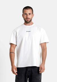 Witte katoenen t-shirt met korte mouwen, ronde halslijn en een klein groen tekstlogo "SIXTHJUNE" gecentreerd op de borst.