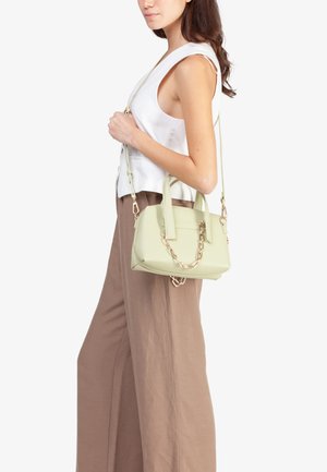 Borsa a mano verde chiaro con una superficie liscia, manici corti e un accento a catena. La borsa presenta una forma strutturata e una tracolla regolabile.