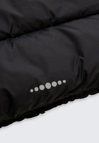 Schwarze gepolsterte Jacke mit glatter, glänzender Oberfläche; verfügt über ein reflektierendes Punktemuster am Saum und einen geschnürten Verschluss am Boden.