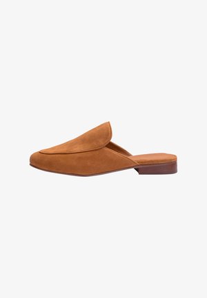 Brun ruskind slip-on mule med lukket, spids tå og flad træhæl, vist fra siden på hvid baggrund.