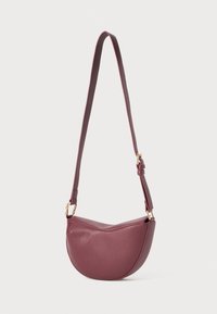 Sac à épaule en cuir bordeaux avec un design incurvé, une sangle ajustable et des accents en métal doré. Texture lisse sans motifs visibles.
