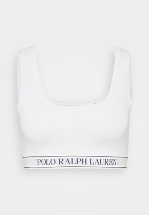 Bralette blanche avec un col large et plongeant et des bretelles épaisses. Il présente une bande de logo contrastante en bas, de couleur bleu marine. Tissu doux et extensible.