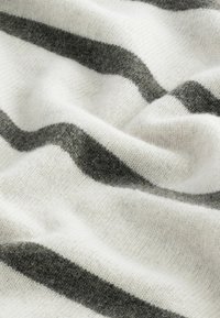 Soft wool blanket featuring alternating dark gray and white horizontal stripes, with a textured surface accentuating its cozy appearance.