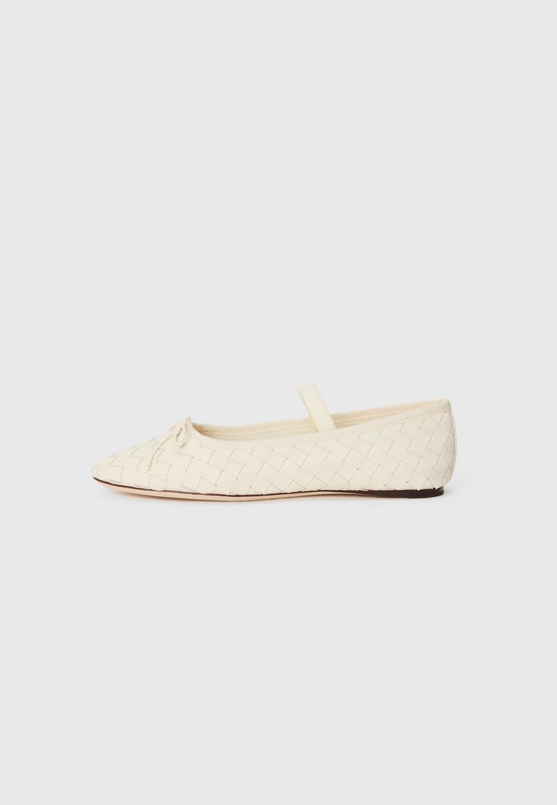 Ballerines en matériau tissé crème, à bout pointu, avec un petit nœud à l'avant et une bride sur le dessus. Semelle plate.