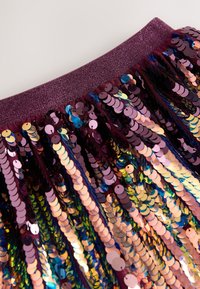 Sequin skirt with a burgundy elastic waistband. Features multicolored shiny round sequins cascading downward, creating a textured appearance.